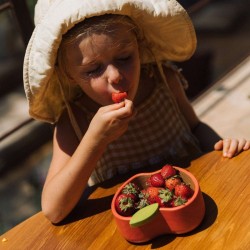 Enfant tenant le bol en bois Lou le citron Oli & Carol rempli de myrtilles